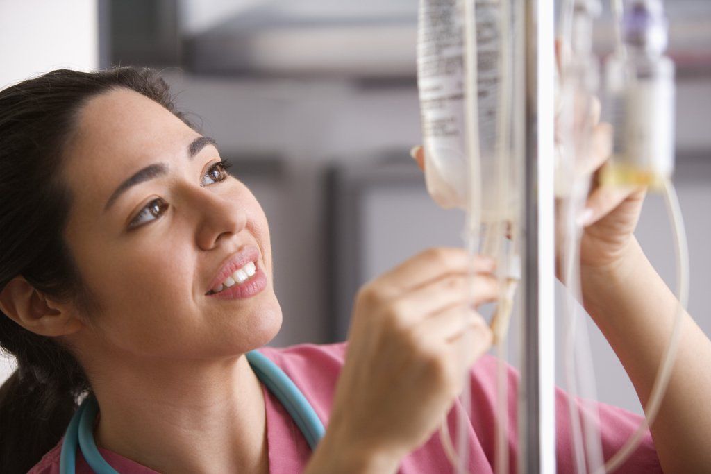 A nurse takes the pulse of a patient.