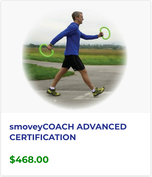 A man in a blue shirt is walking with two green rings in his hands