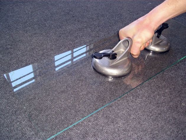 A person is holding a piece of glass with two suction cups. — Luffys Glass in South Murwillumbah, NSW