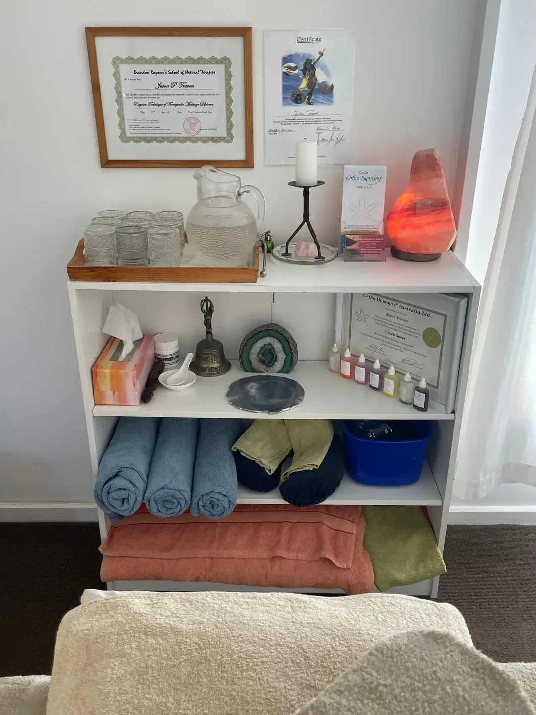 A shelf filled with towels , candles , and other items — Aloha Therapeutic Massage In Gillen, NT