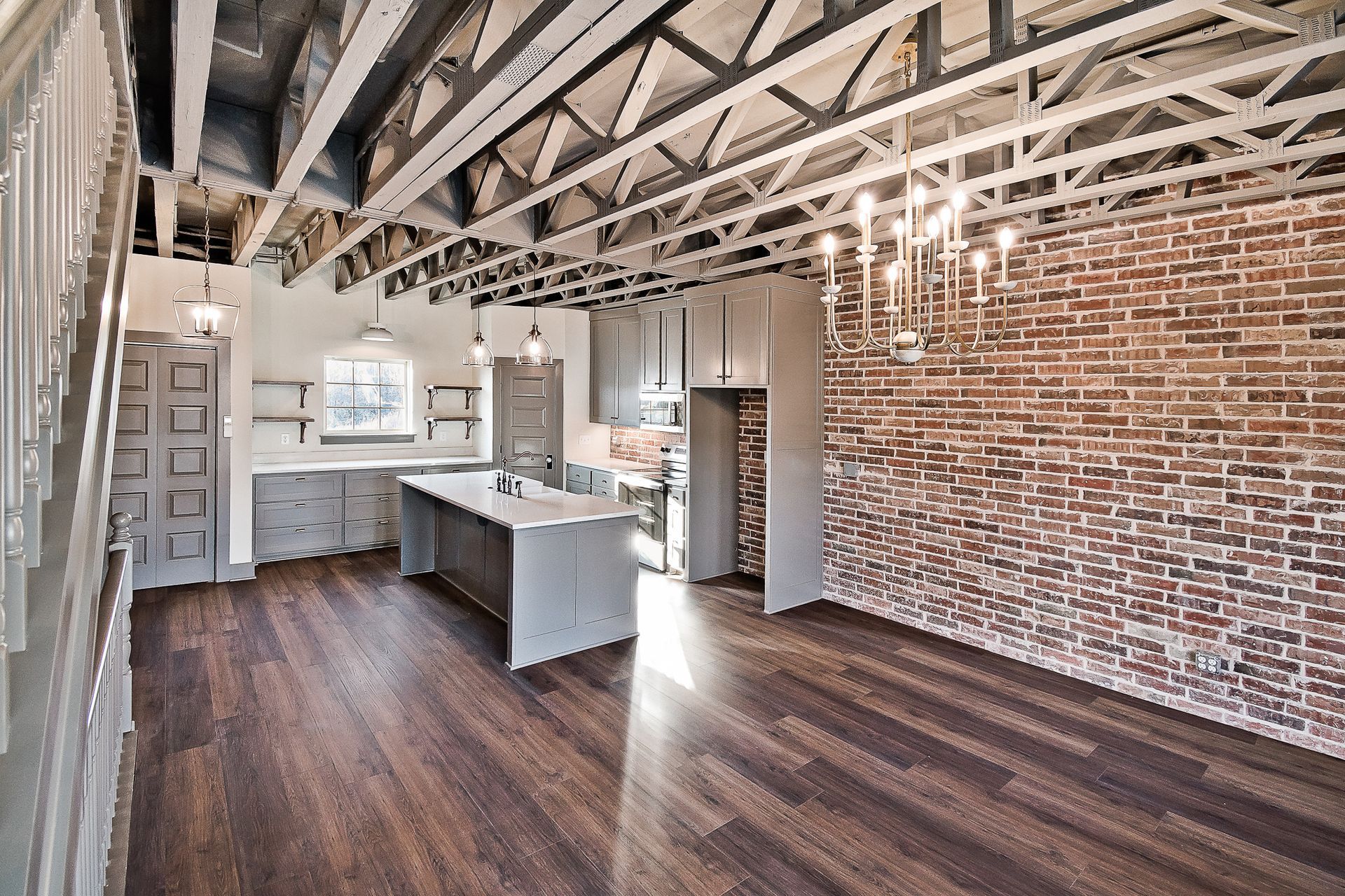 Modern brick and dark-paneled townhouses at dusk, set against a twilight sky and grassy landscape.