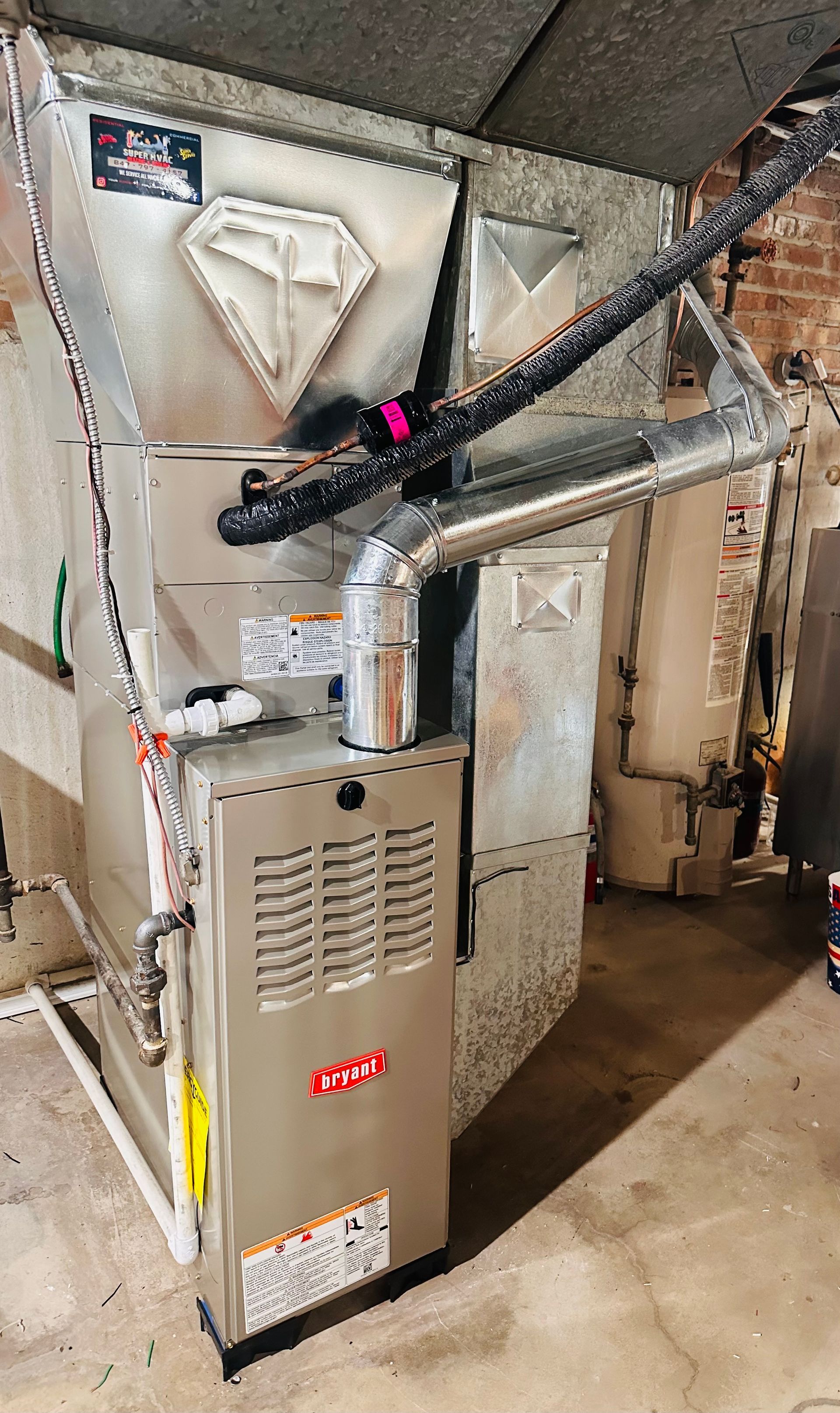 Basement furnace and HVAC ductwork with metal vents and piping, viewed close up
