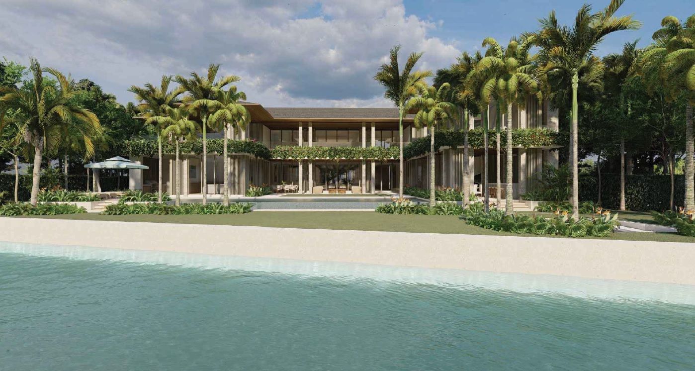 Beachfront mansion with a sandy beach and palm trees.