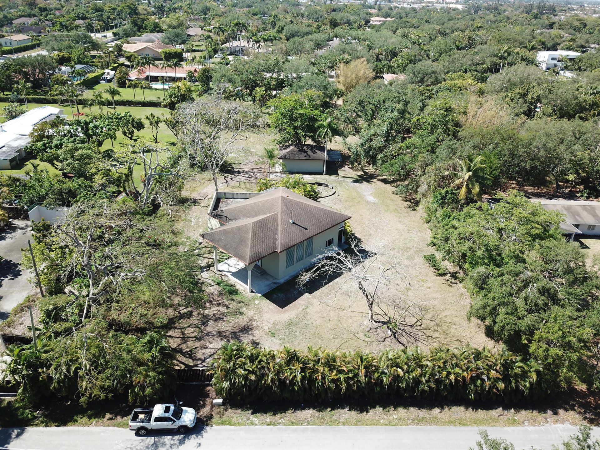 An aerial view of a house surrounded by trees and bushes.