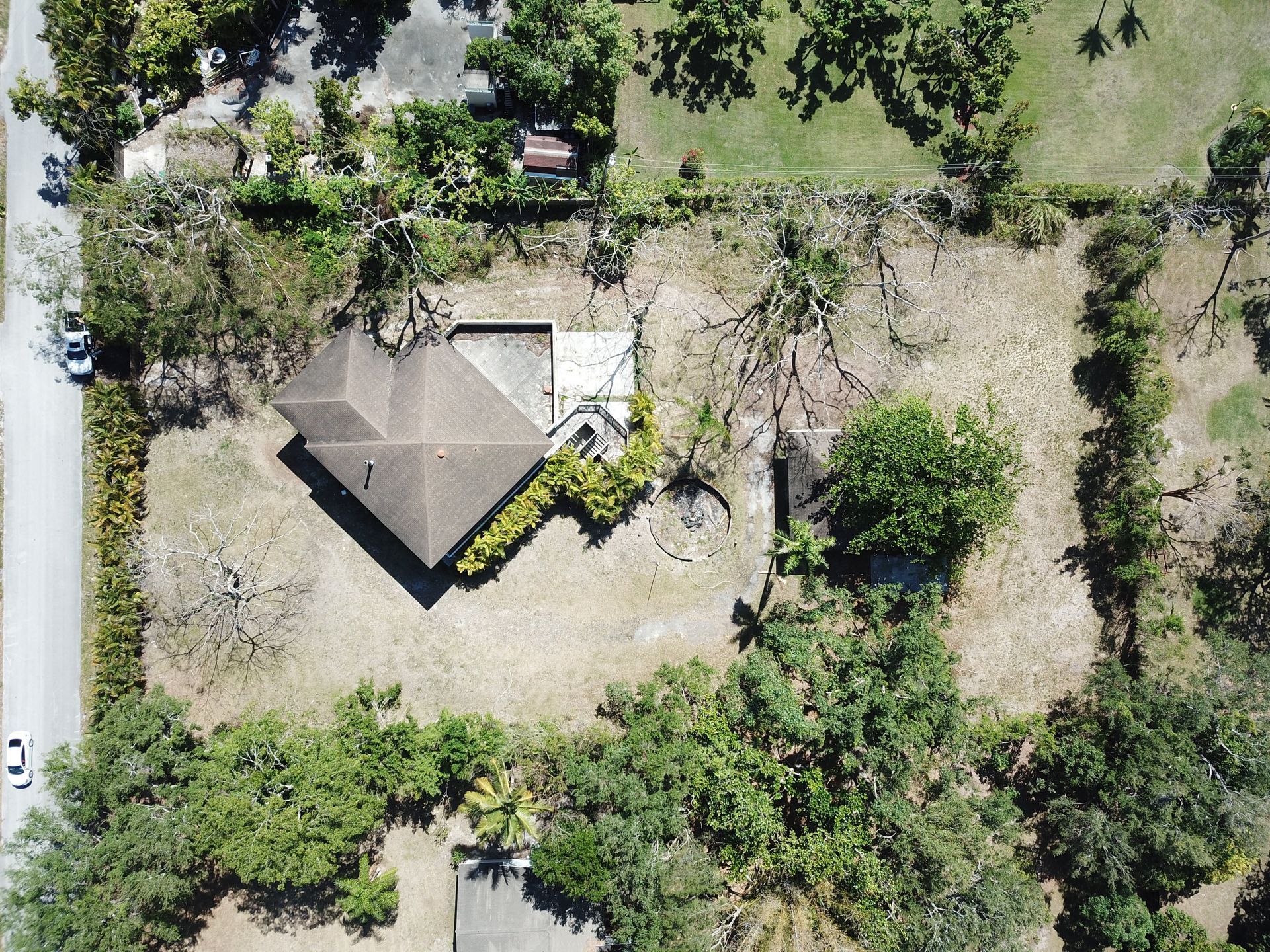 An aerial view of a house surrounded by trees and grass.