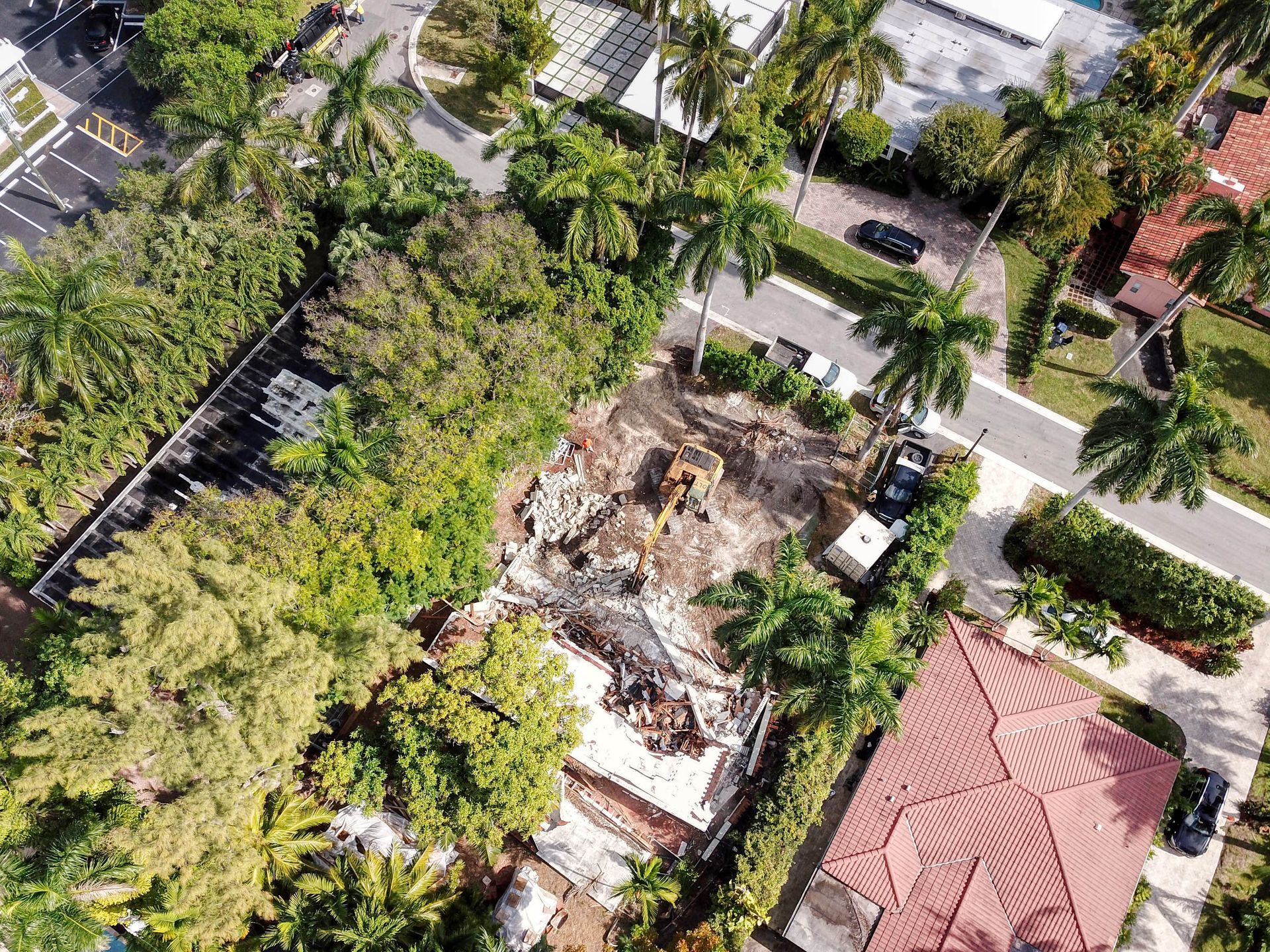 An aerial view of a house being demolished in a residential area.