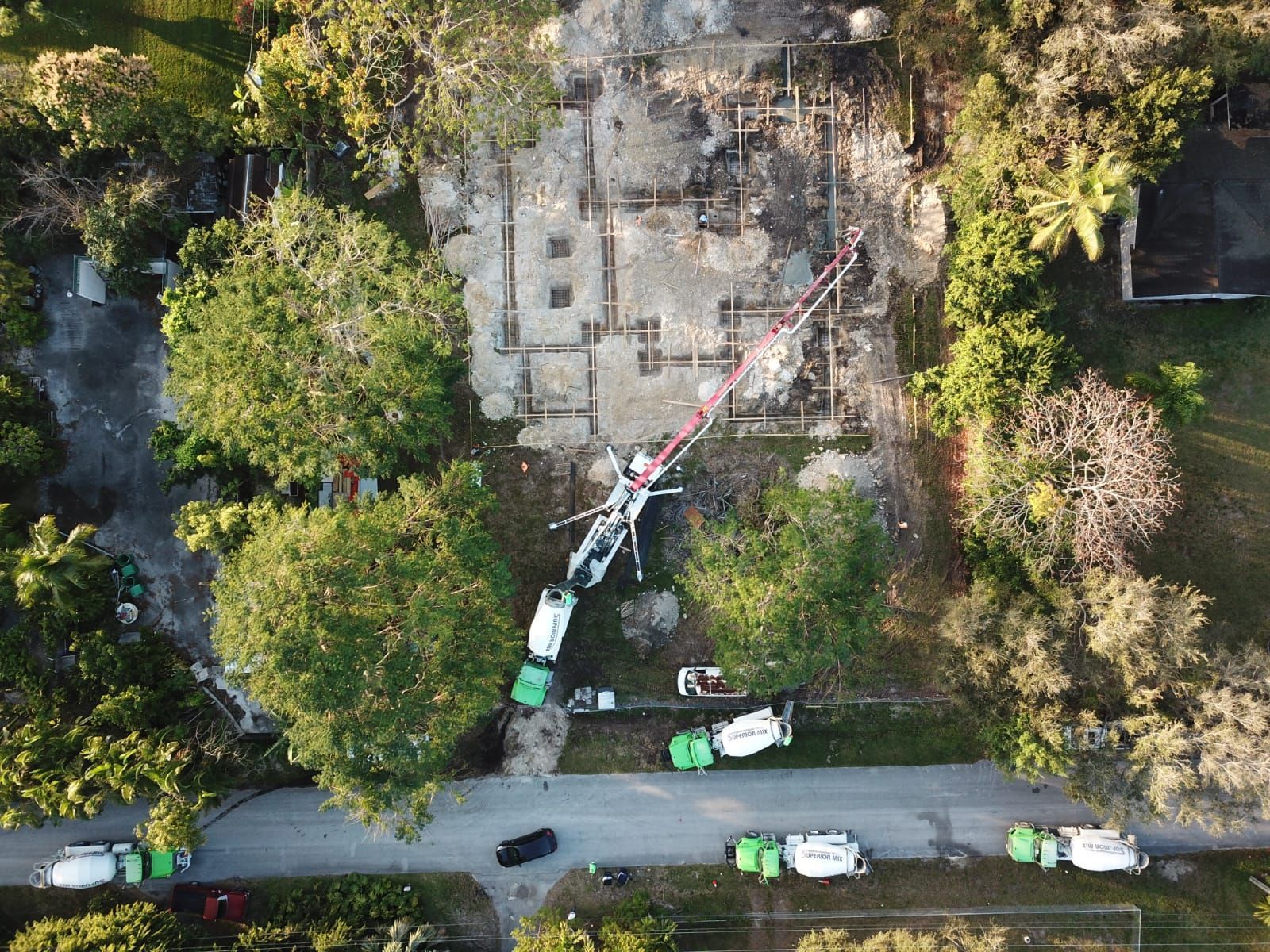 An aerial view of a construction site with trucks and a crane.