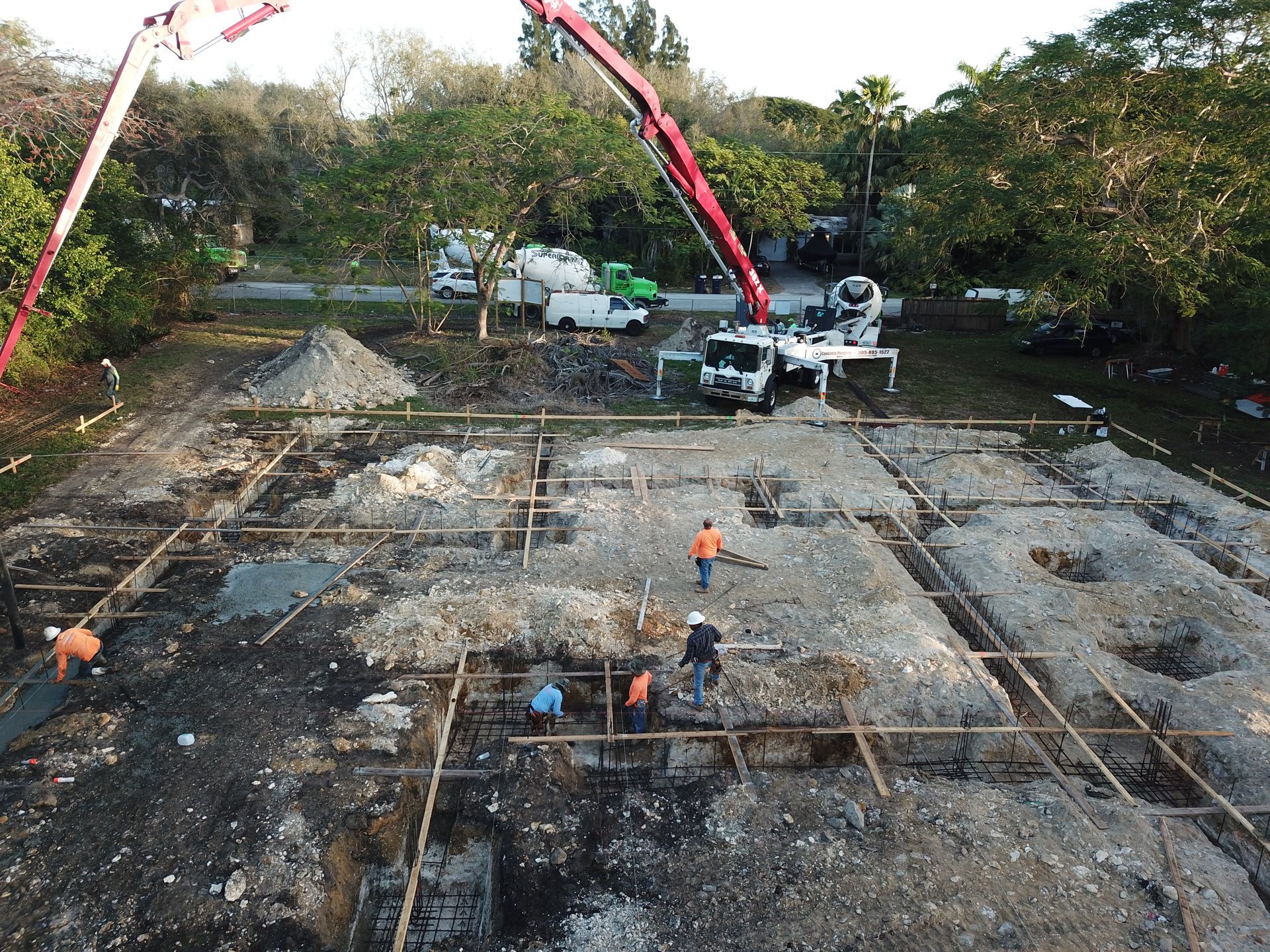 An aerial view of a construction site with a concrete pump and workers.
