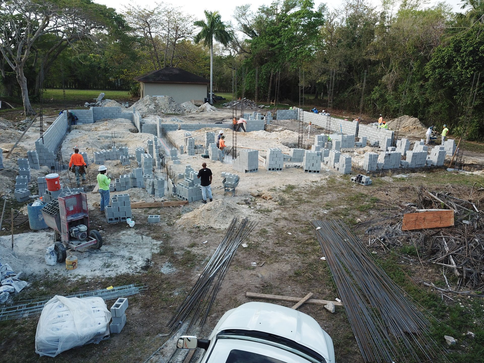 An aerial view of a construction site with workers and a white truck.
