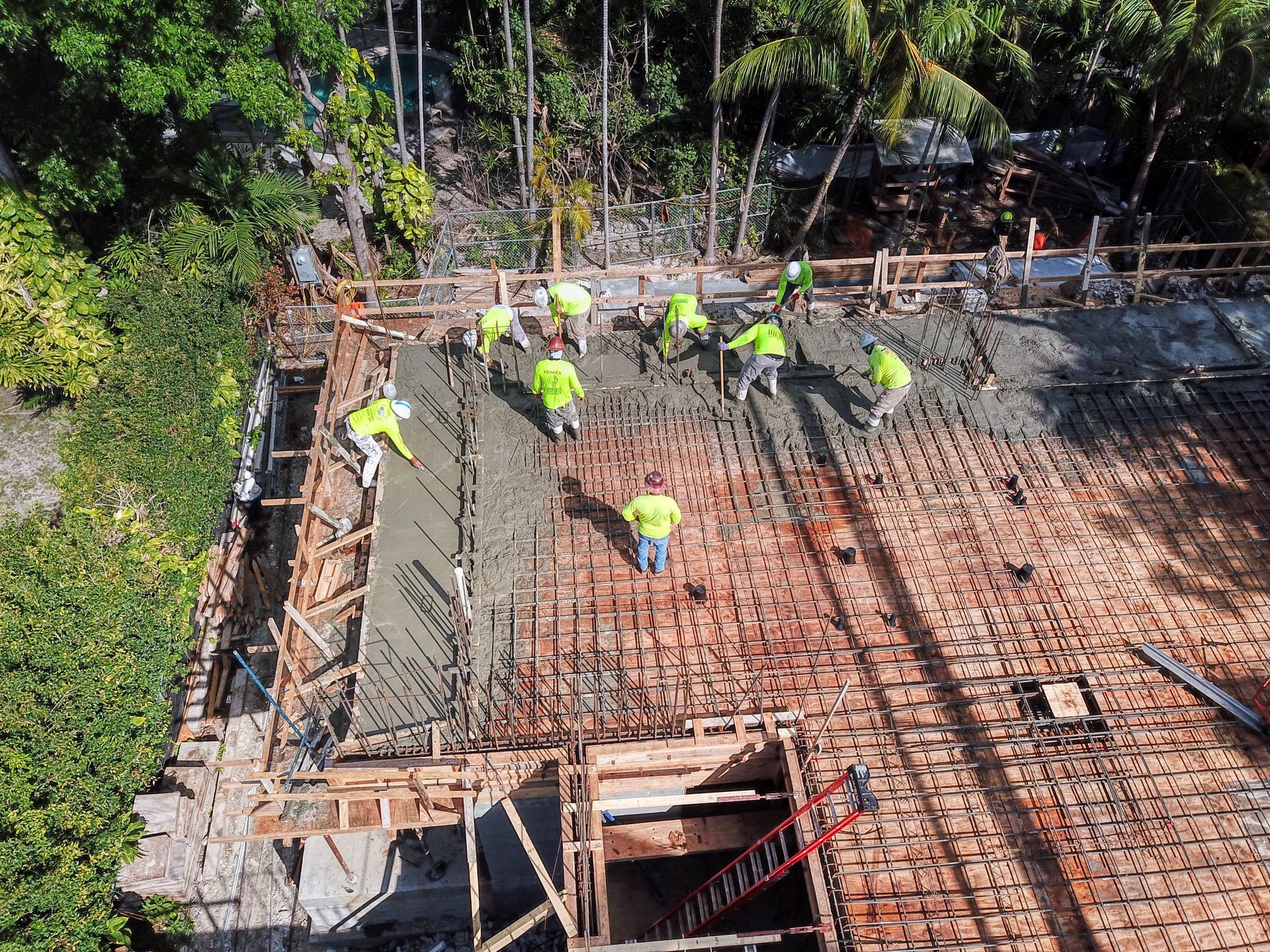 An aerial view of a construction site with workers pouring concrete.