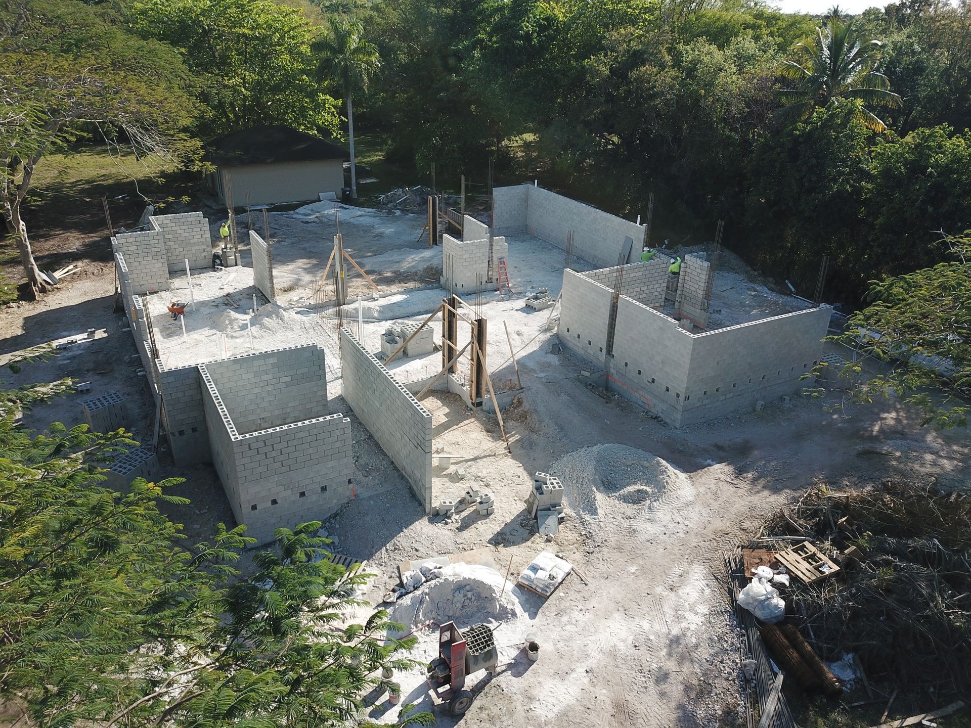 An aerial view of a building under construction in the middle of a forest.