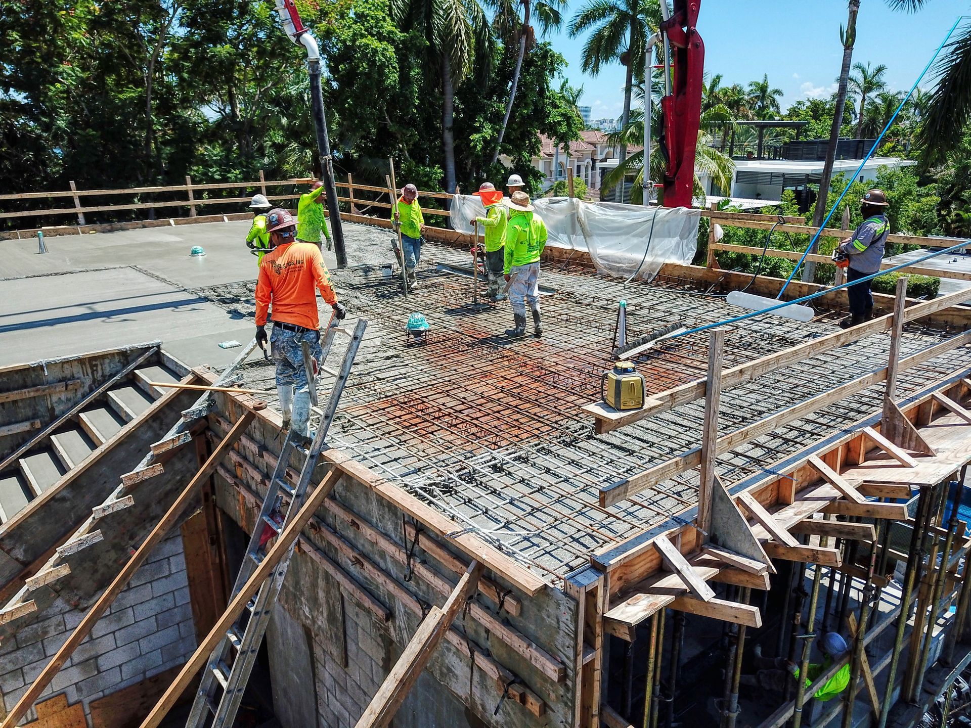 A group of construction workers are working on a concrete floor.