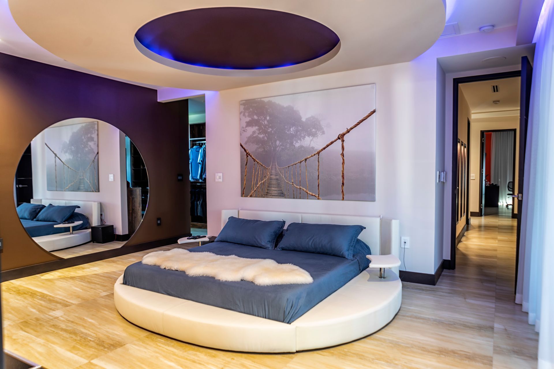 Bedroom with a round bed, large mirror, and ceiling lighting.