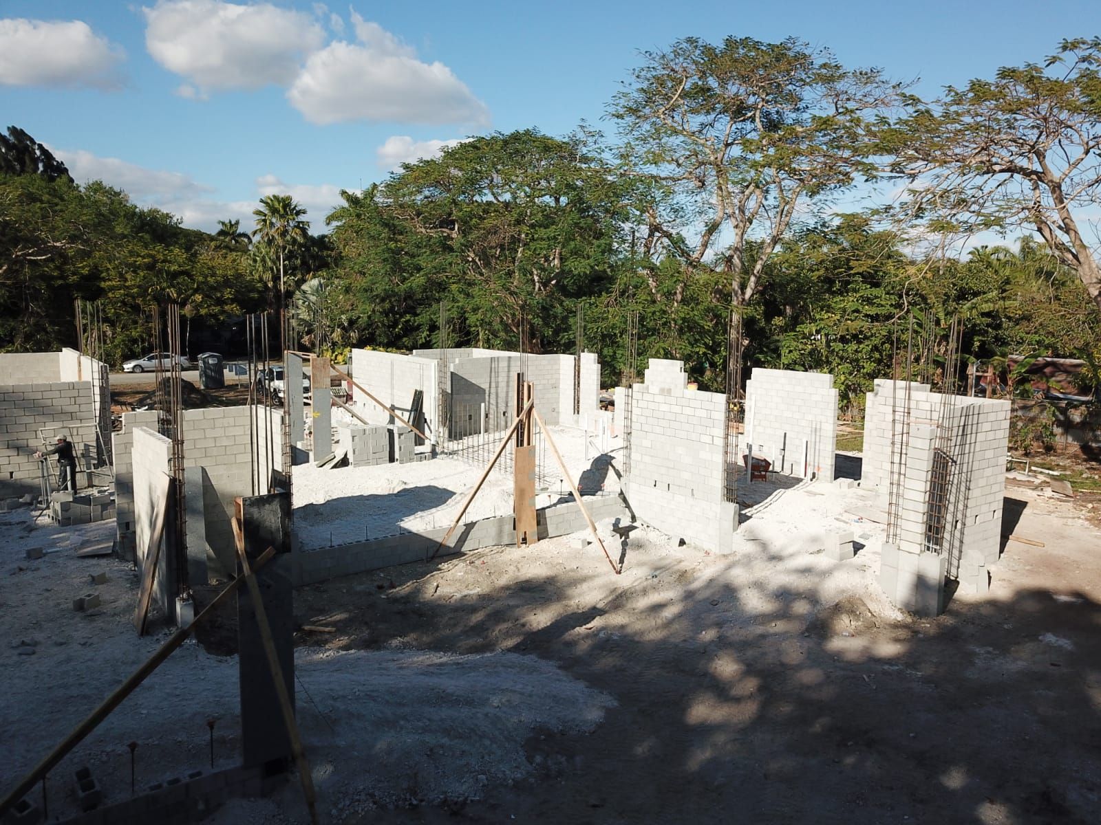 A construction site with a lot of concrete blocks and trees in the background