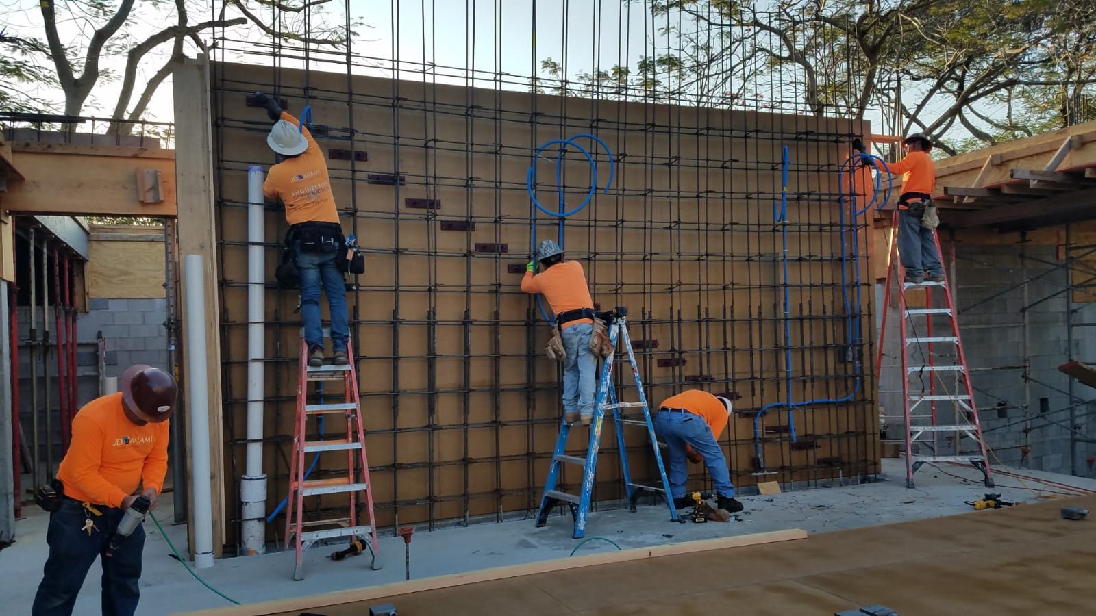 A group of construction workers are working on a wall
