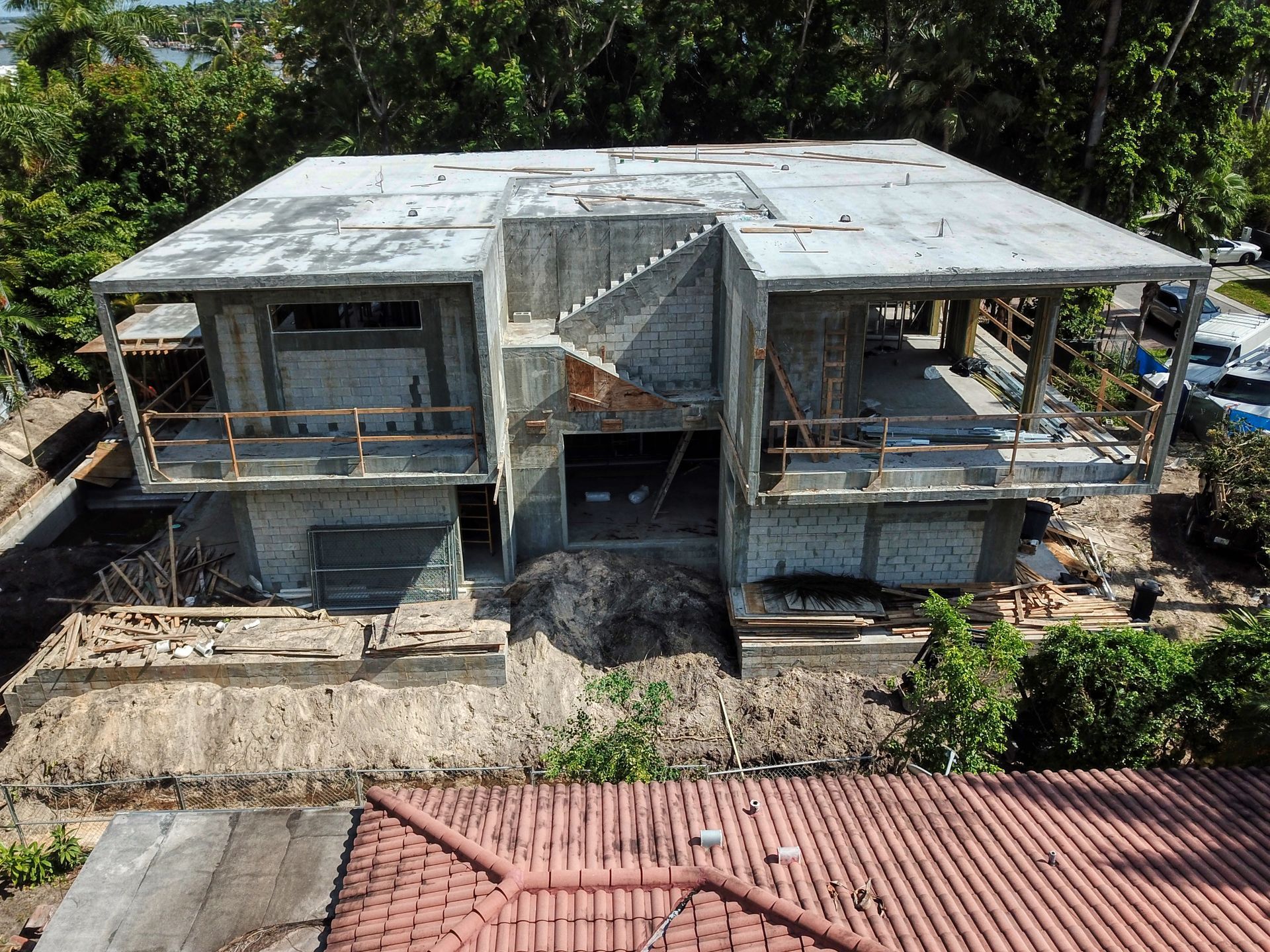 An aerial view of a house under construction with a red tile roof.
