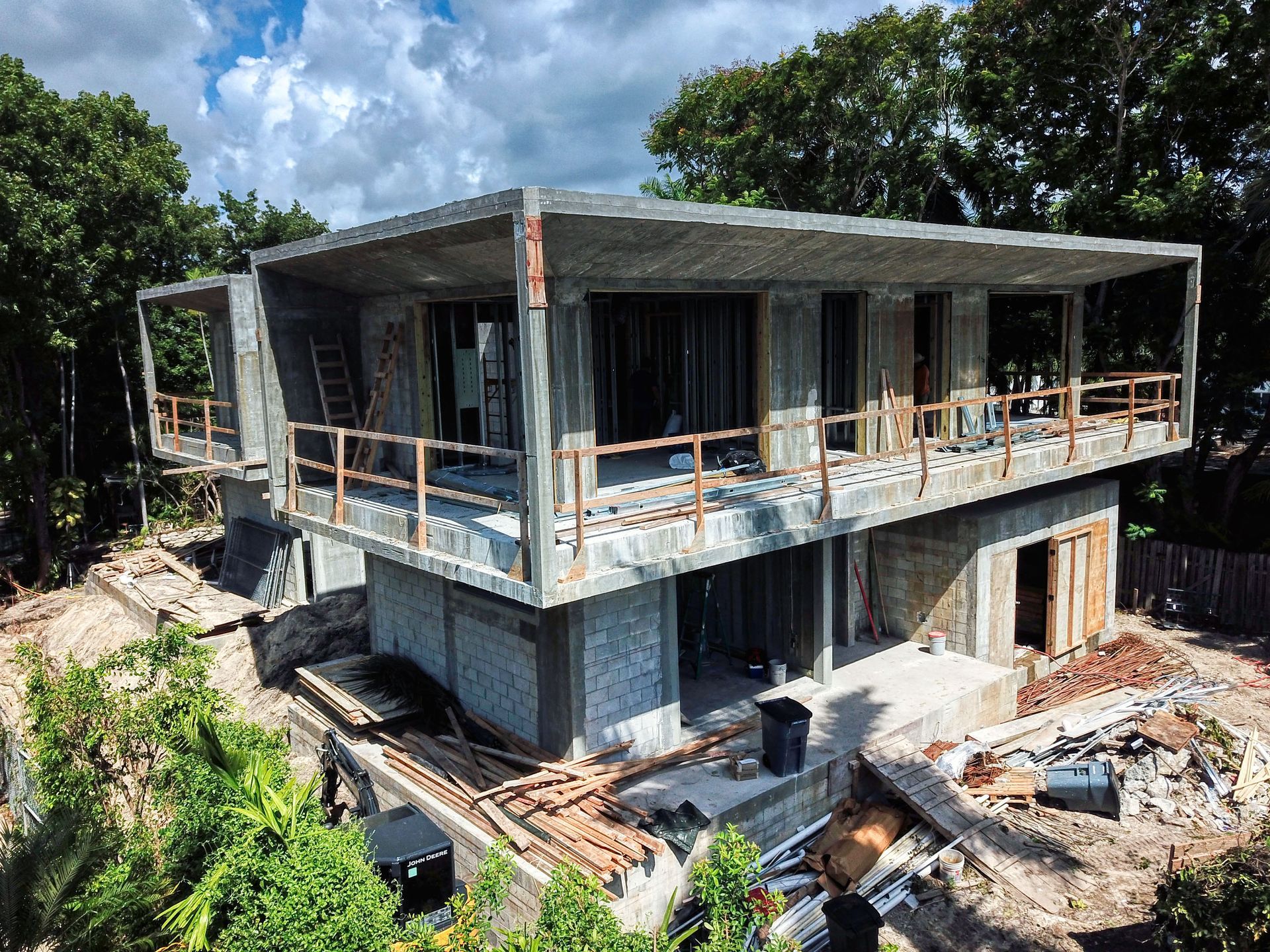 An aerial view of a house under construction in the middle of a forest.