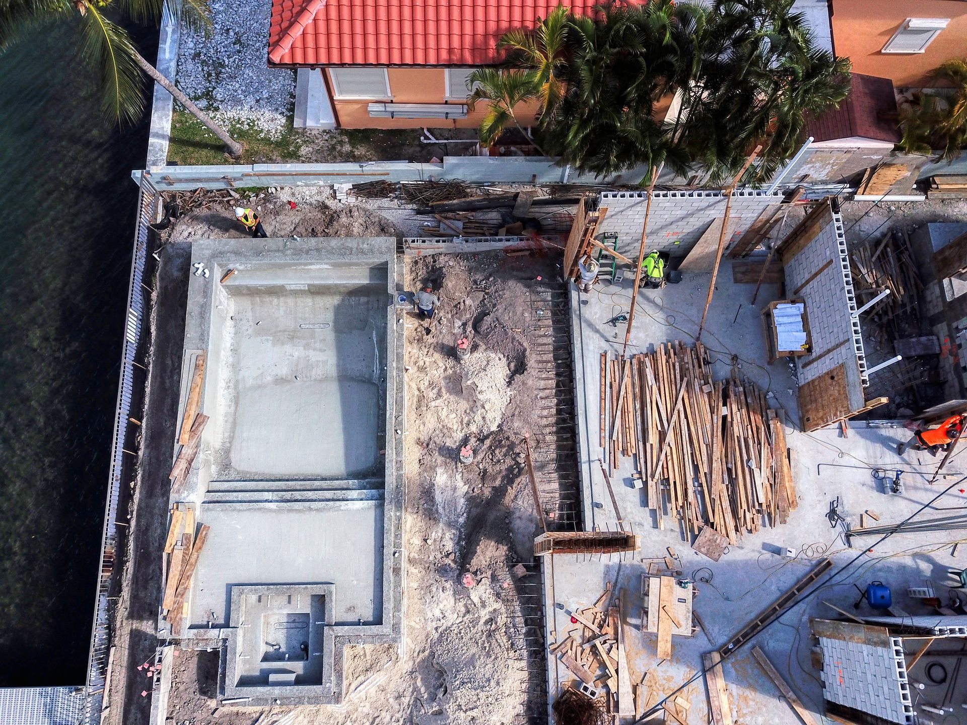 An aerial view of a construction site with a house in the background.