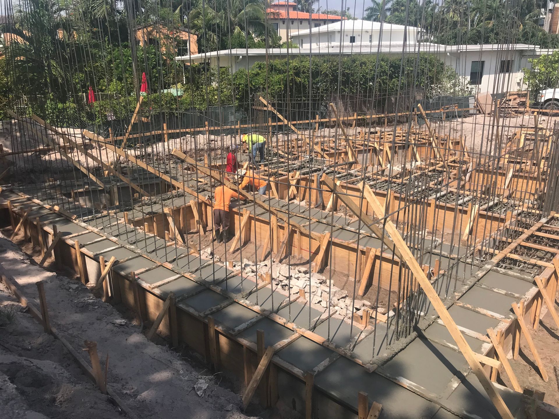 Construction site with wooden forms, rebar, and concrete.