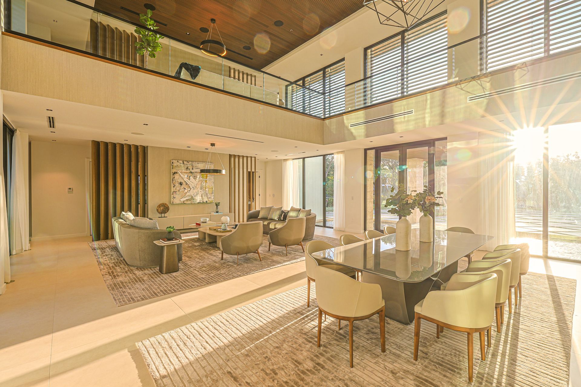 Spacious, modern living and dining area with high ceilings, natural light, and a second-floor balcony.