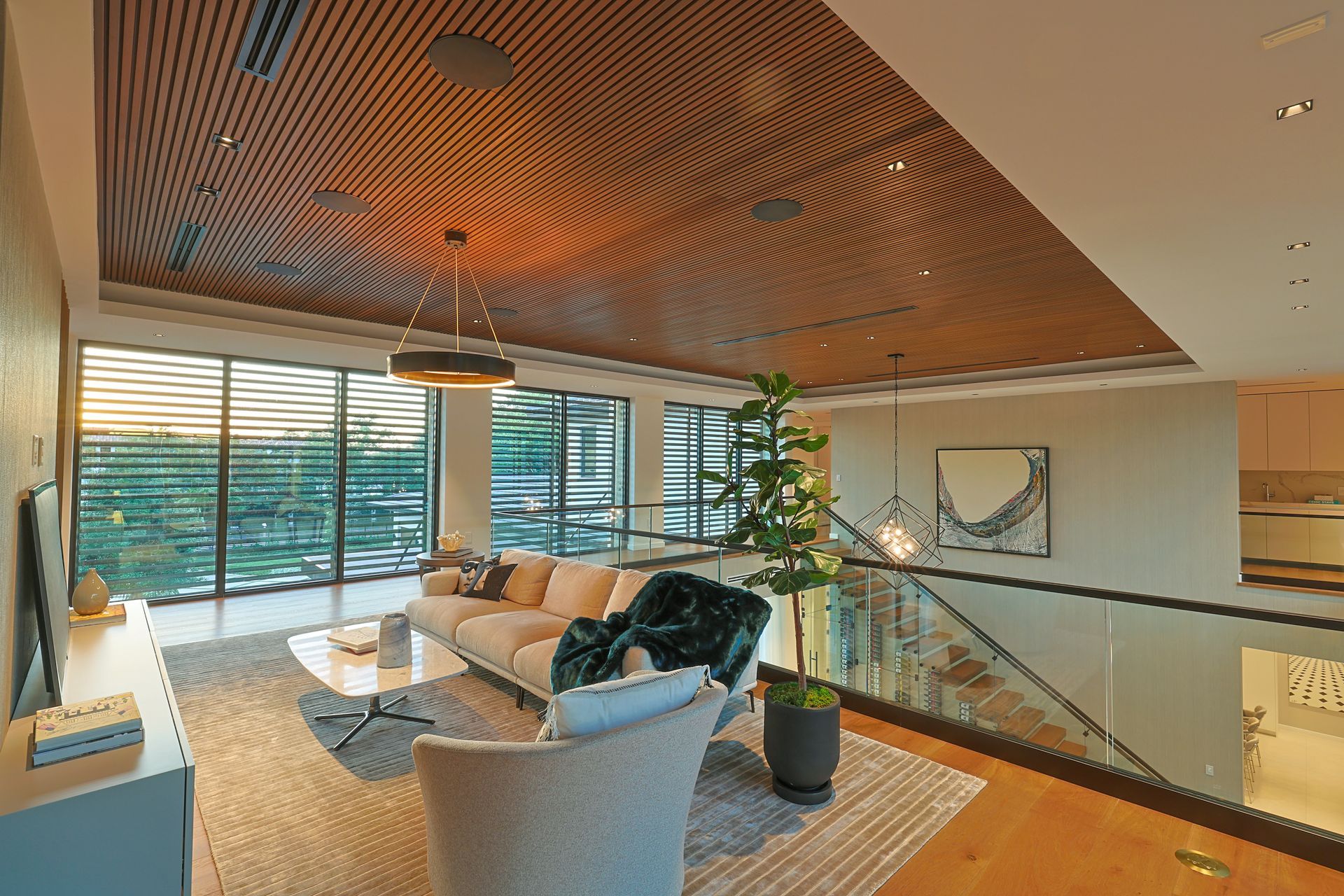 Modern living room with wood ceiling, large windows, and balcony.