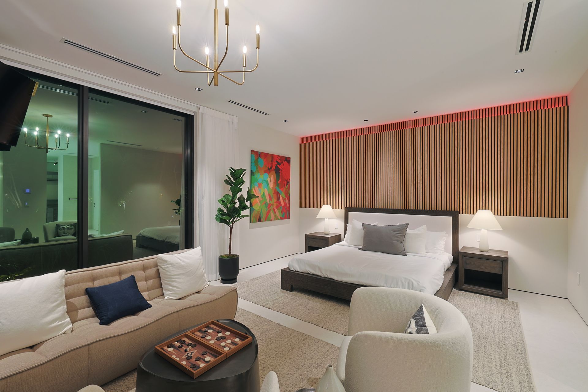 Modern bedroom with bed, seating area, large window, and wooden accent wall.