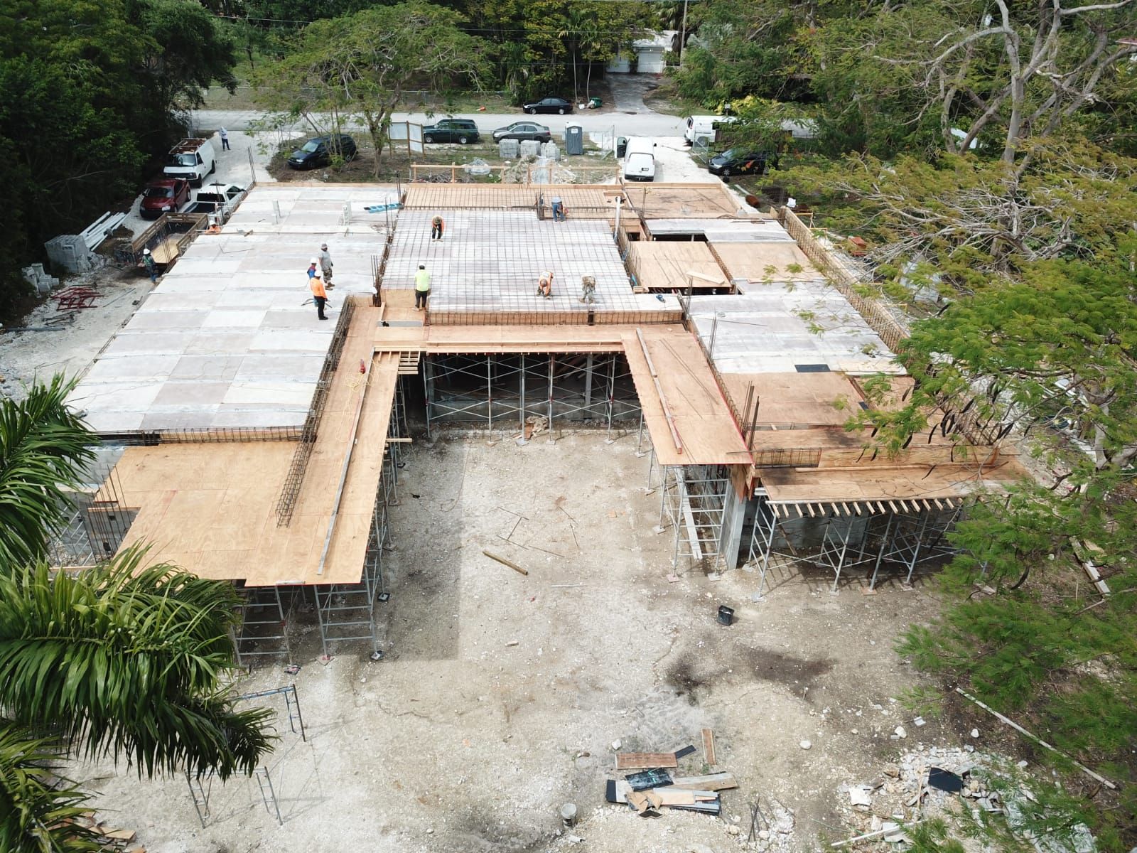 An aerial view of a large building under construction surrounded by trees.