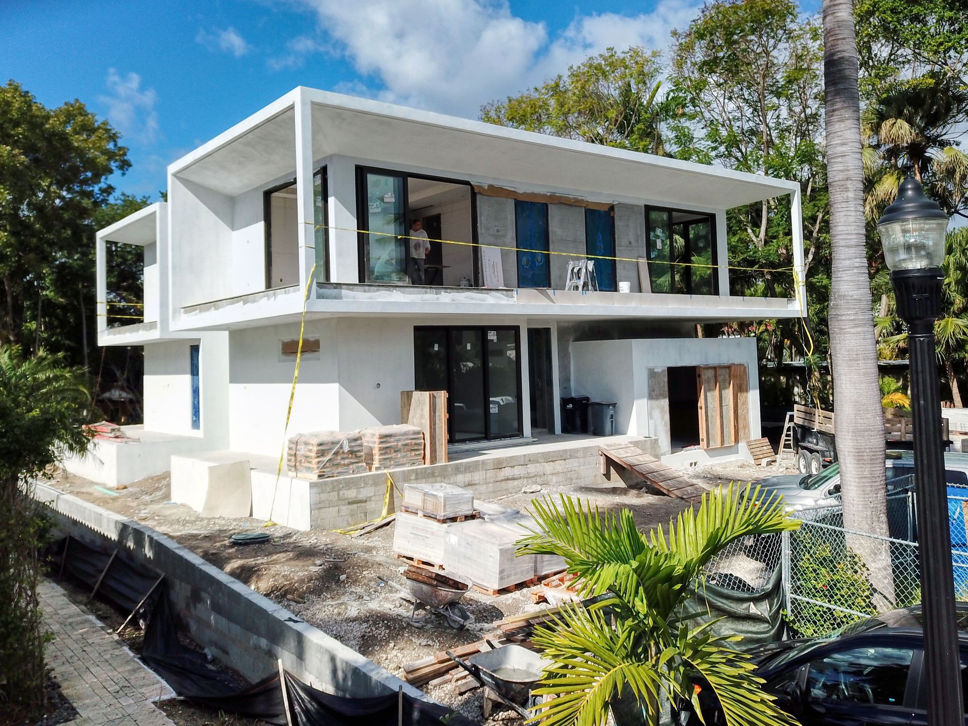 A large white house is being built in the middle of a forest.