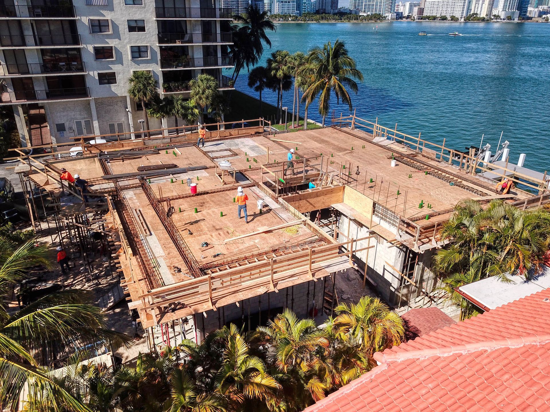 An aerial view of a building under construction next to a body of water.