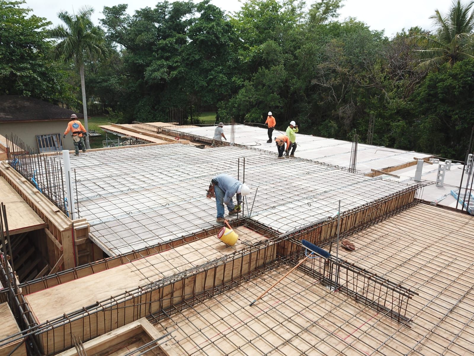 A group of construction workers are working on a concrete floor.