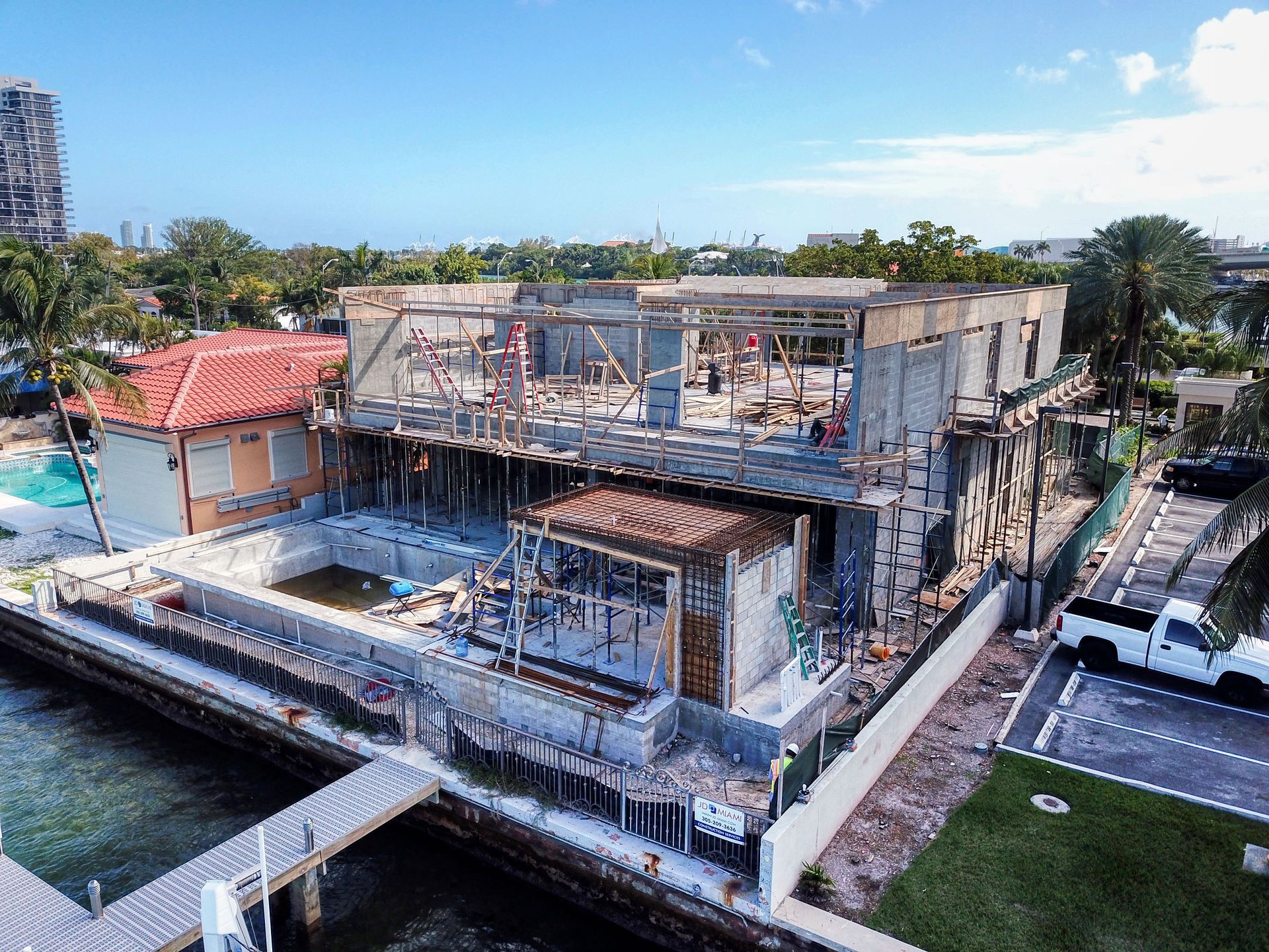 An aerial view of a house under construction next to a body of water.