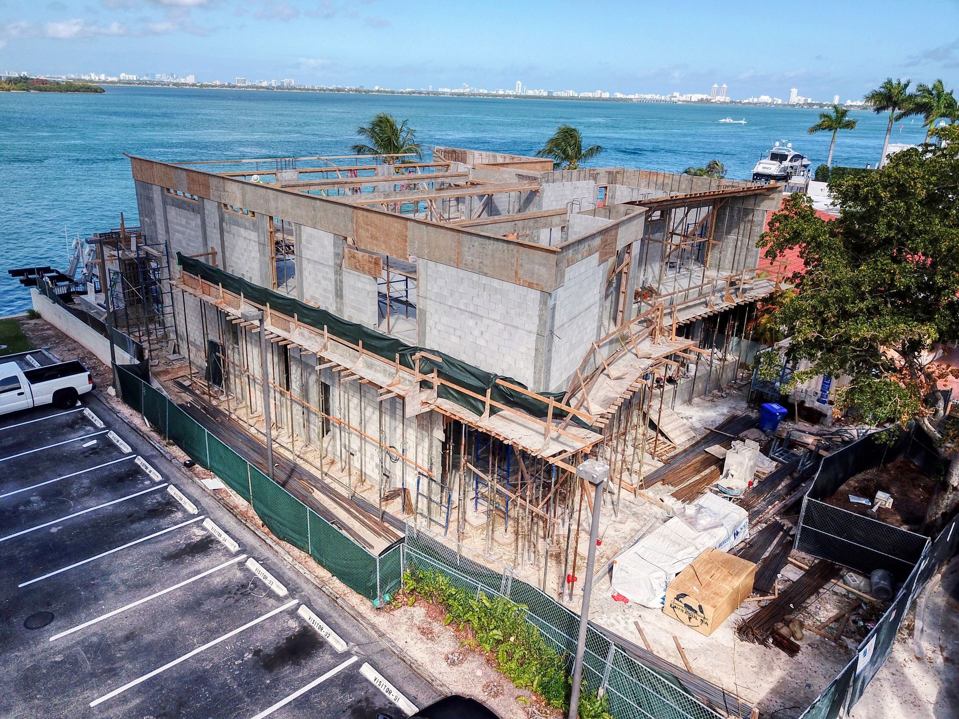 An aerial view of a building under construction next to a body of water.