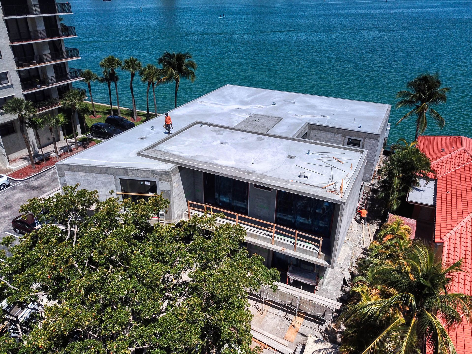 An aerial view of a building under construction next to a body of water.