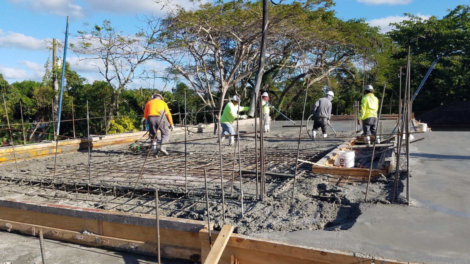 A group of construction workers are working on a concrete floor.