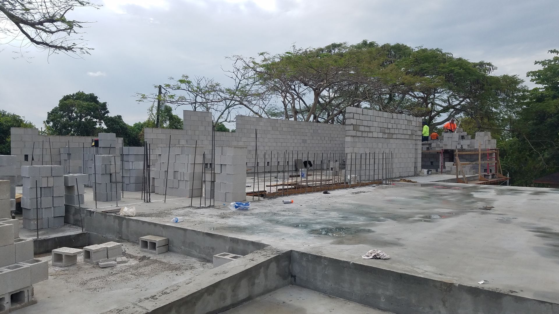 A construction site with a lot of bricks and trees in the background