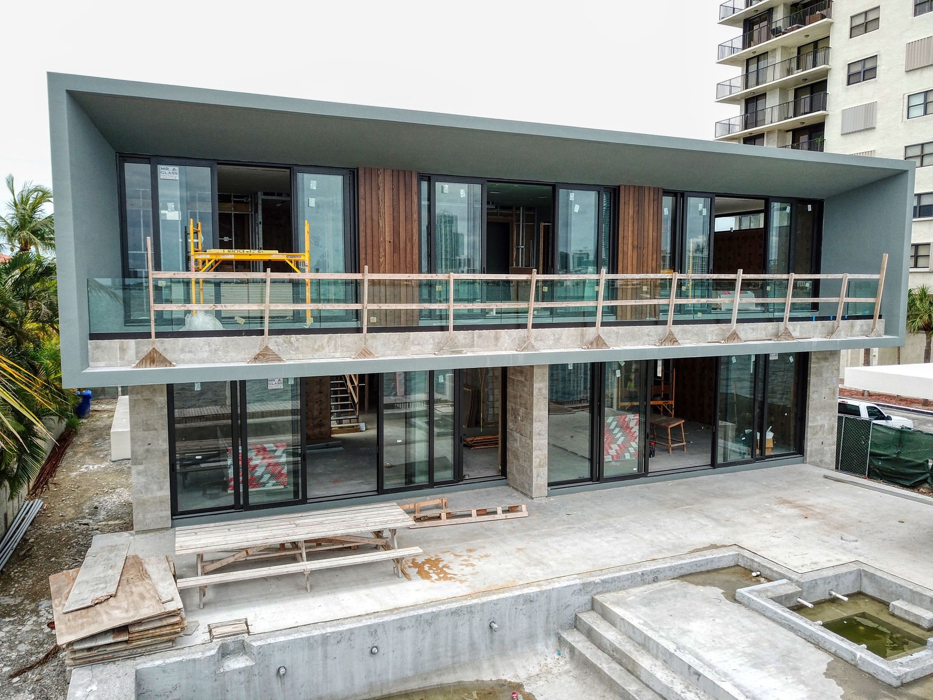 An aerial view of a house under construction with a swimming pool.