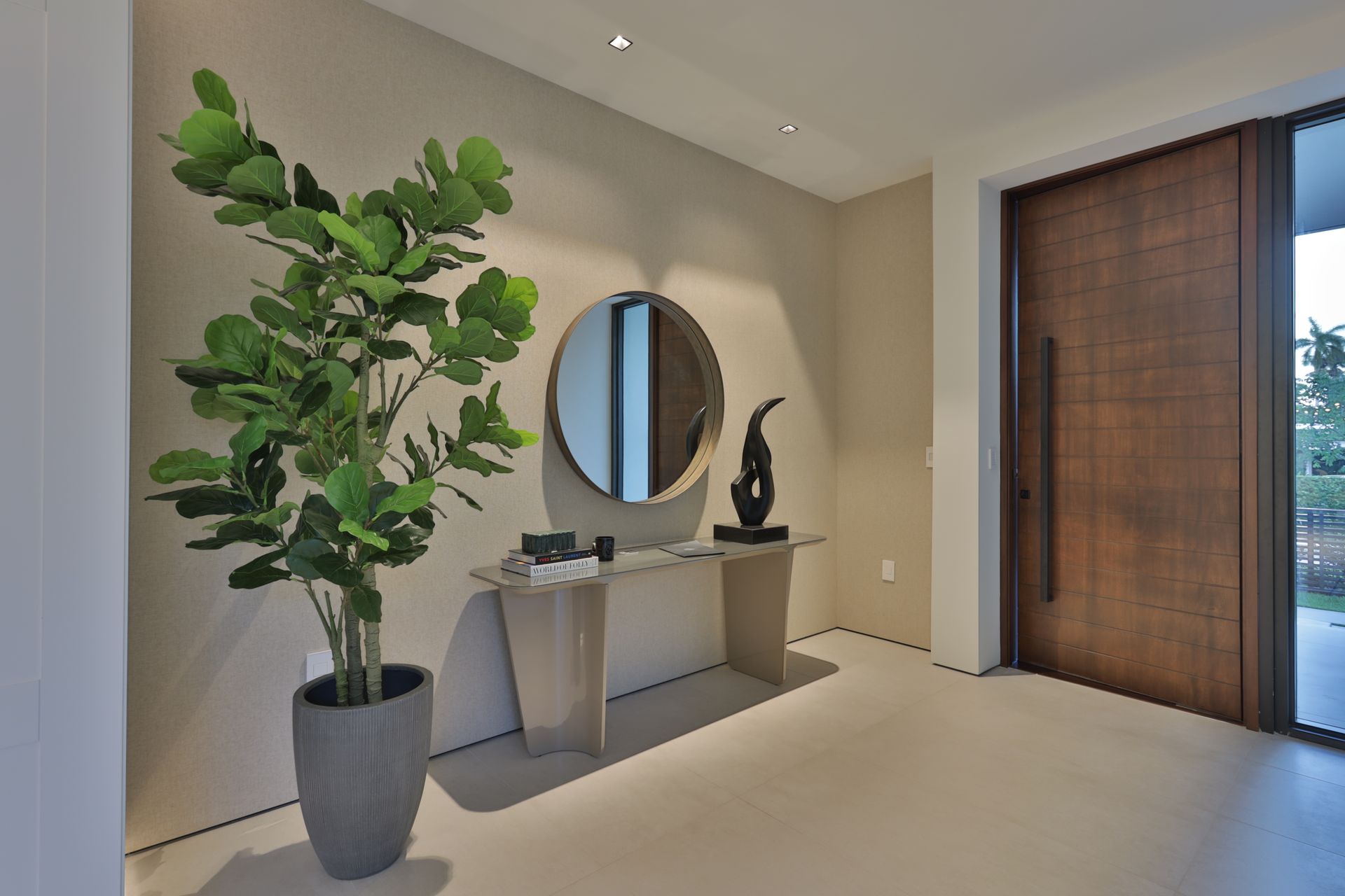 A potted plant is sitting on a table in a hallway next to a mirror.