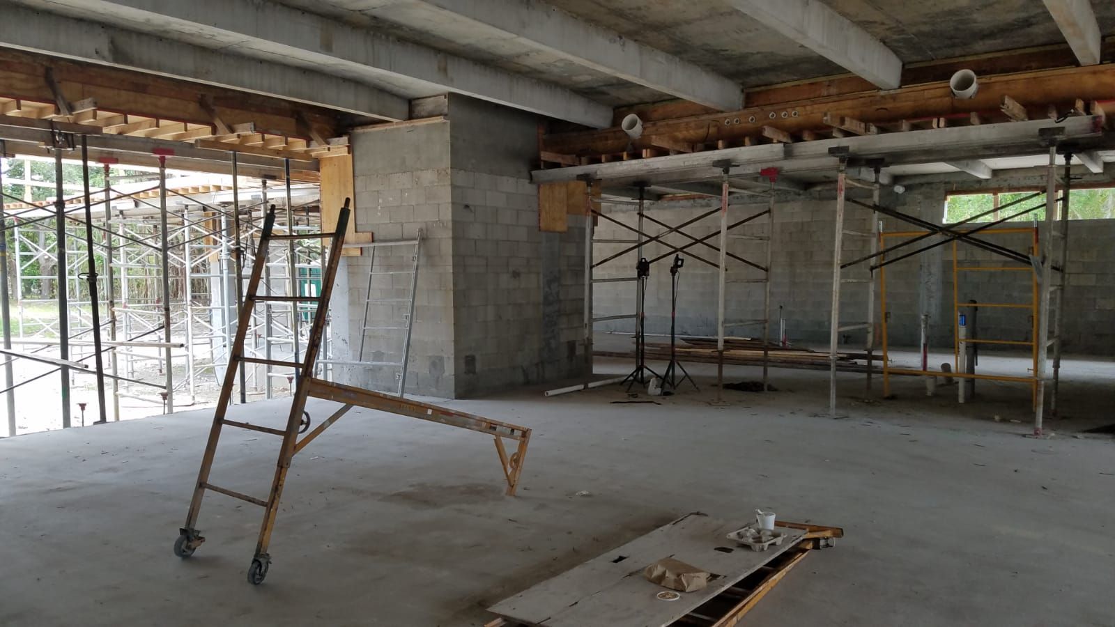 An empty room with a ladder and scaffolding in it