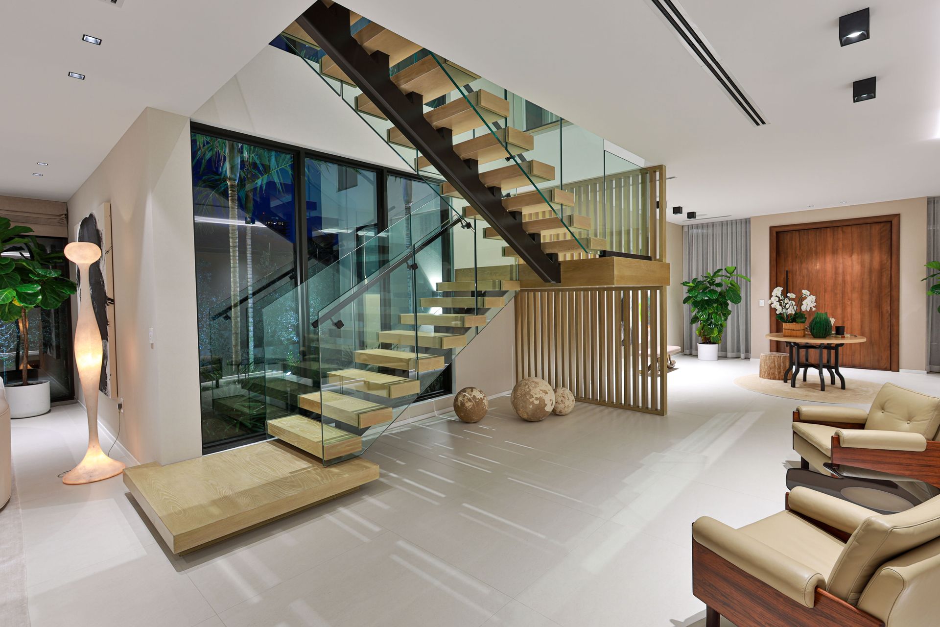 A living room with a staircase and chairs in it