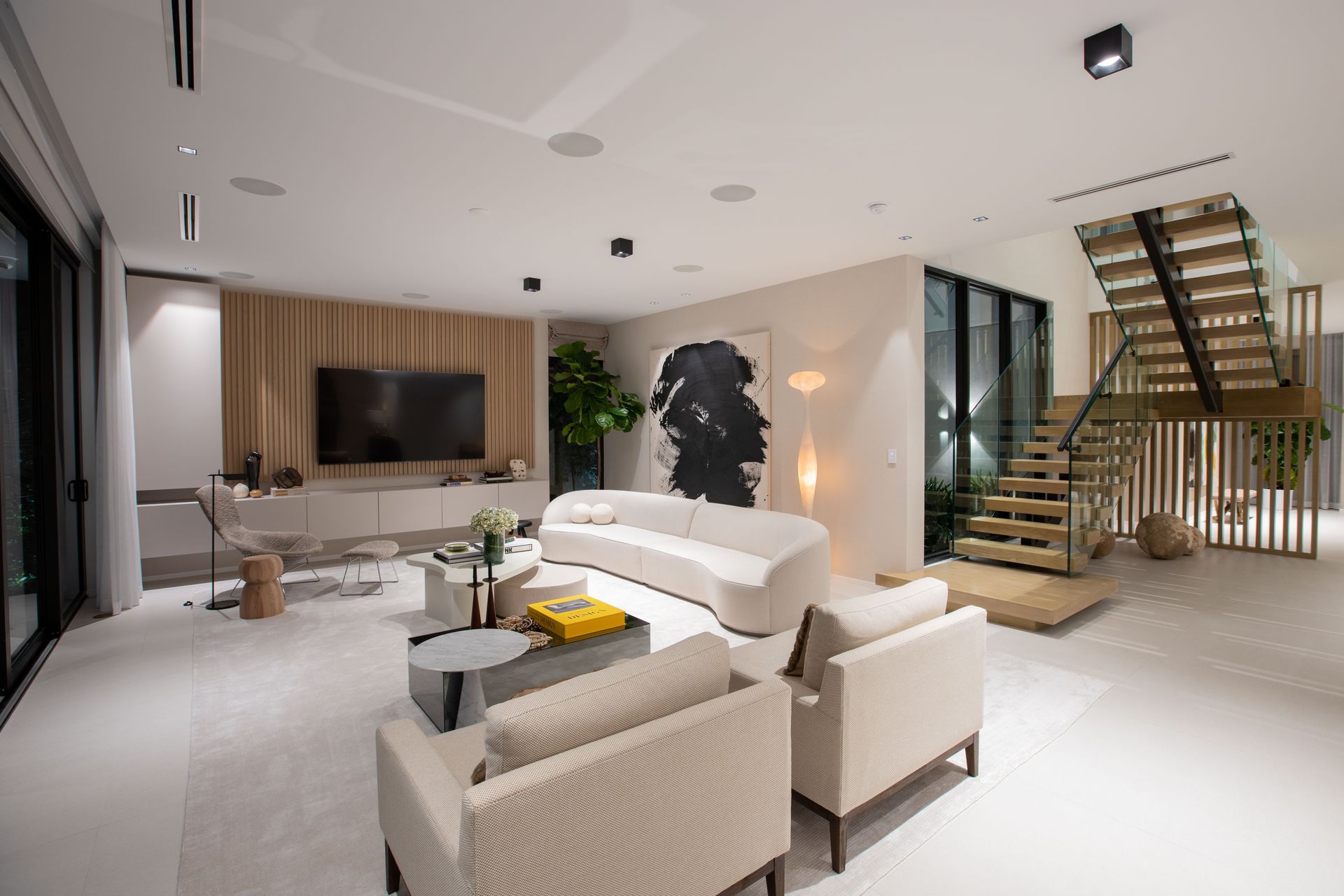 A living room with a couch , chairs , table and television.