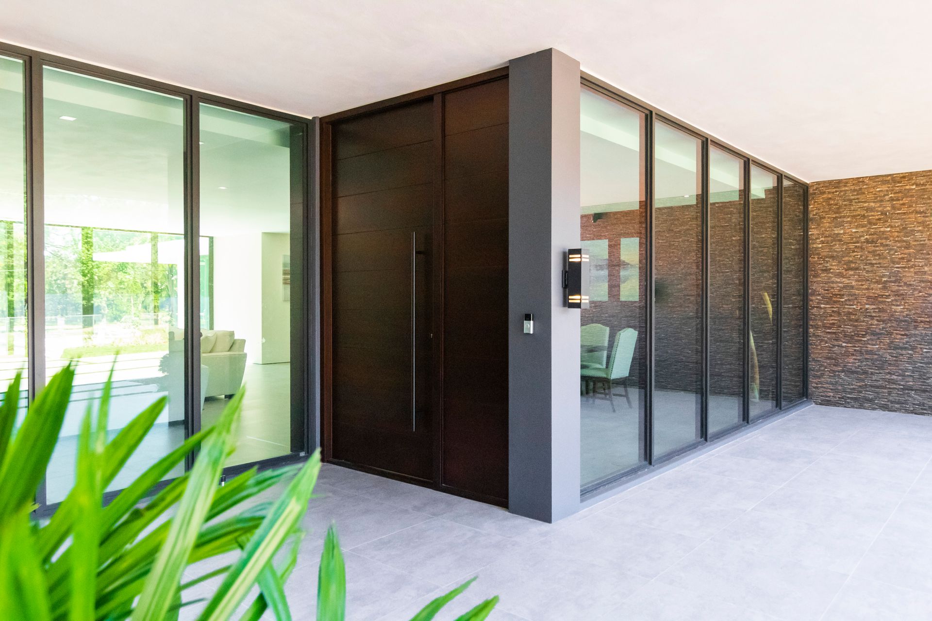 A modern house with a large door and lots of windows