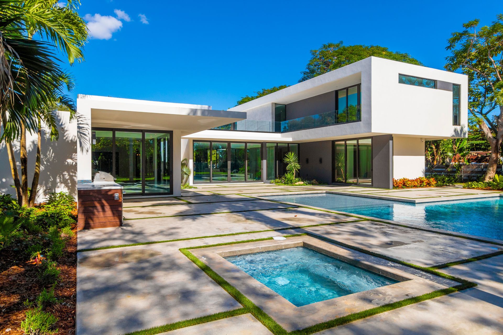 A modern house with a large swimming pool in front of it.