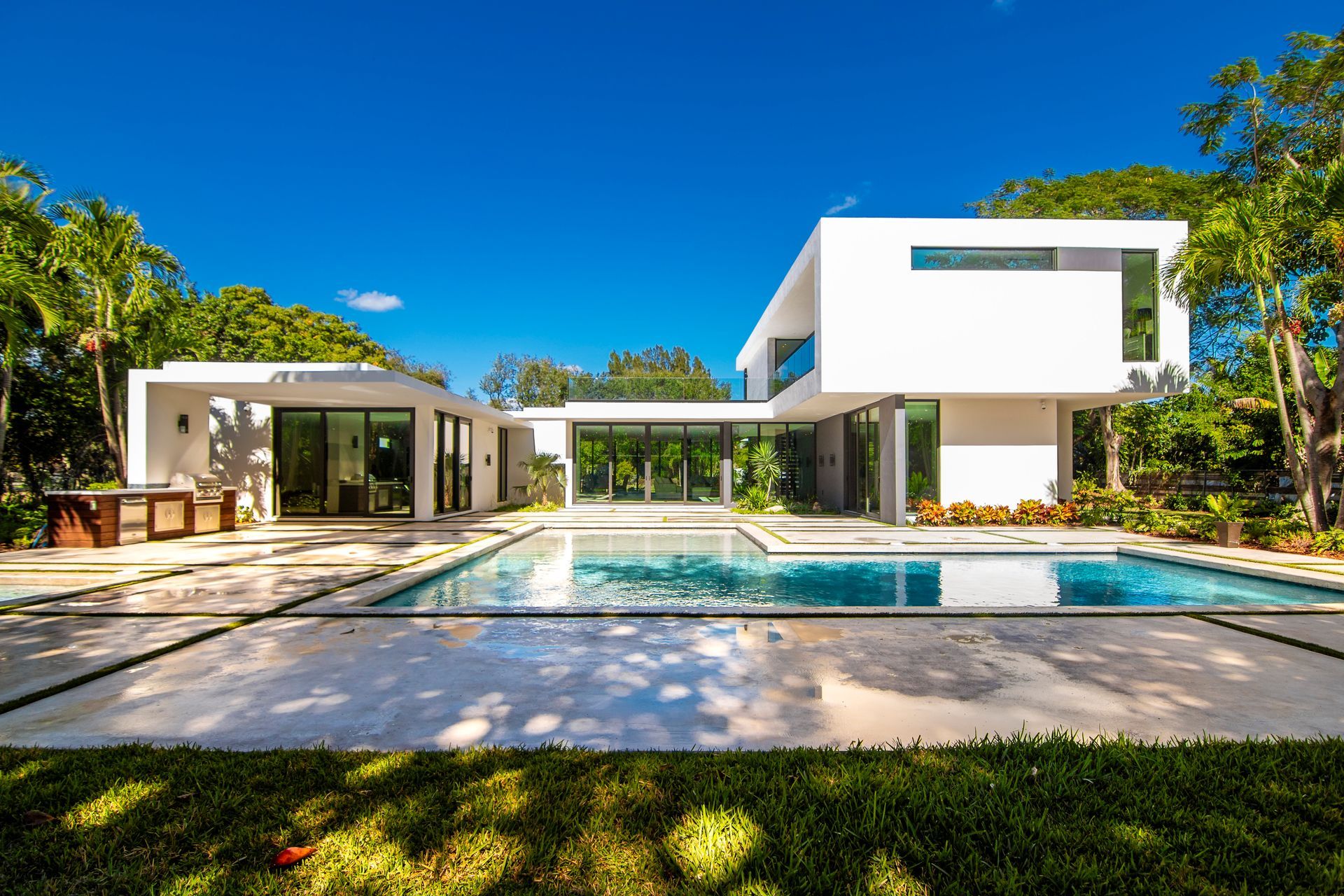 A large white house with a large swimming pool in front of it