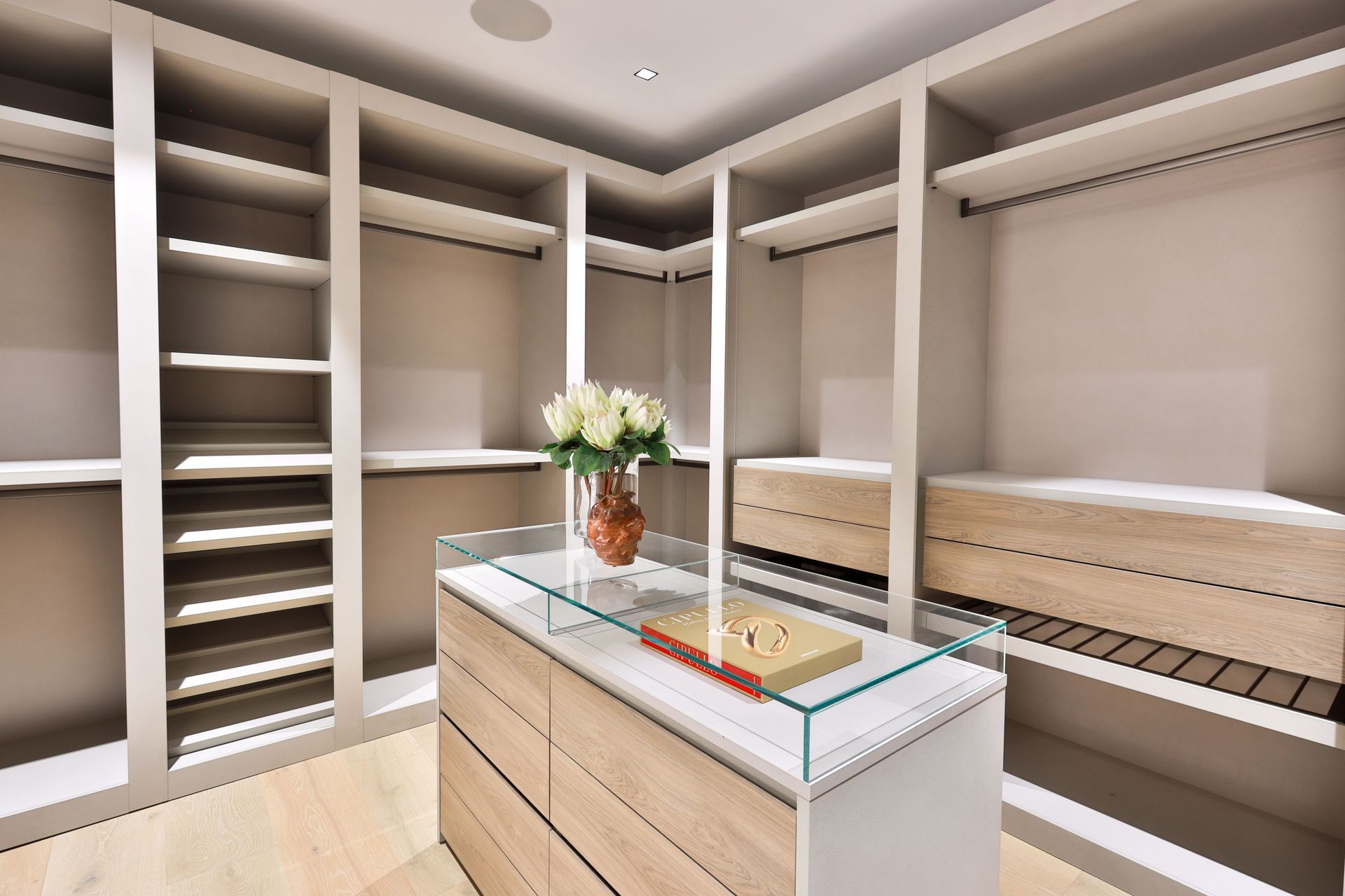A walk in closet with lots of shelves and drawers