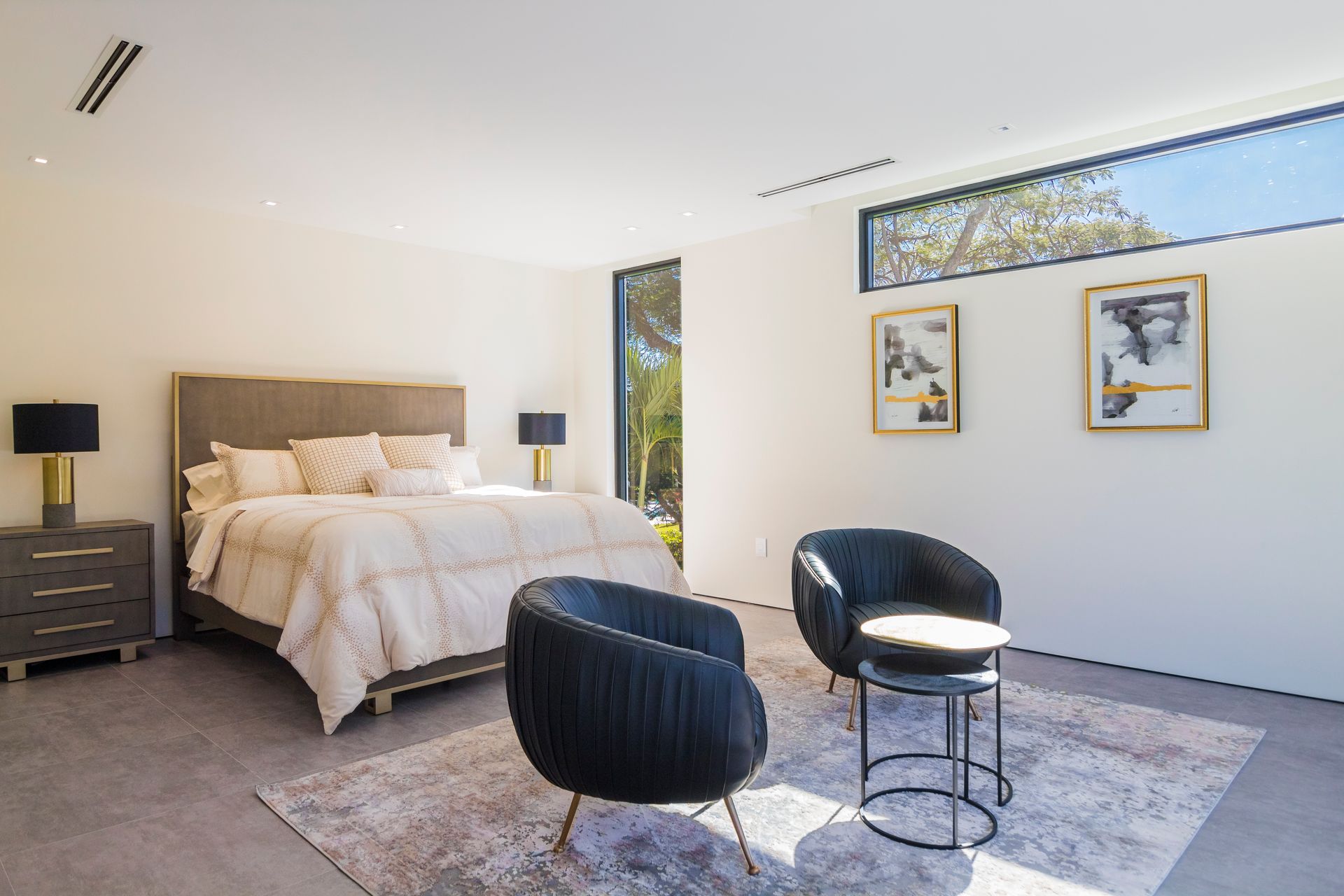 A bedroom with a large bed , two chairs and a table.