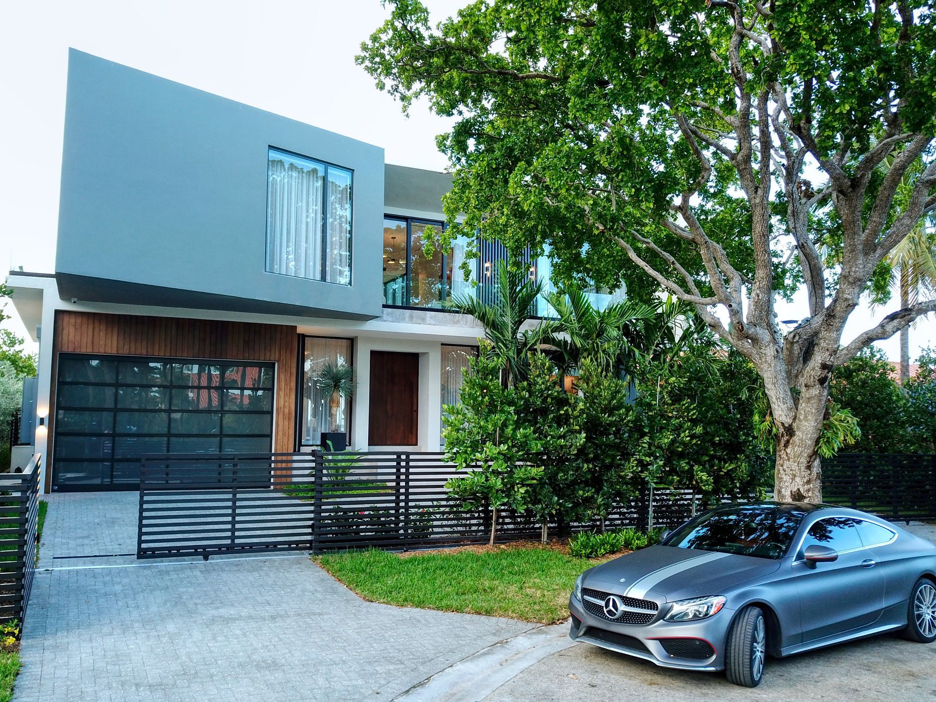 A car is parked in front of a modern house
