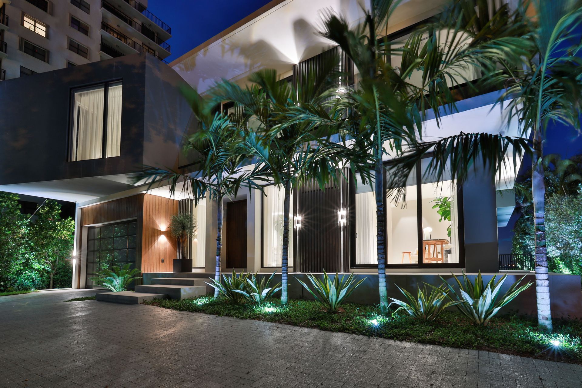 A large house with lots of windows and palm trees in front of it