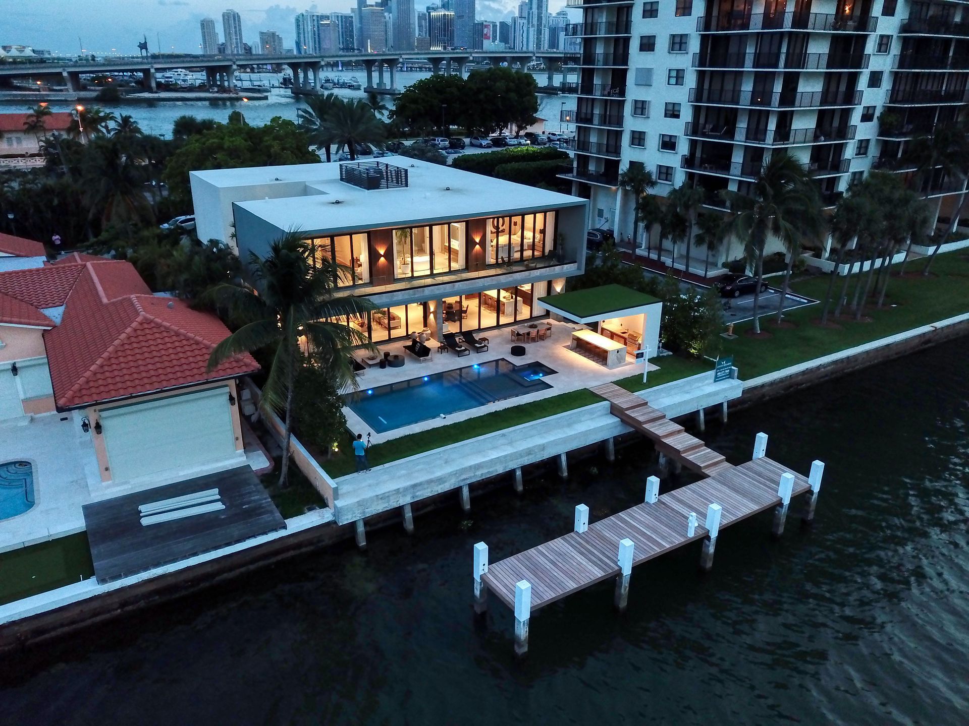 An aerial view of a large house next to a body of water