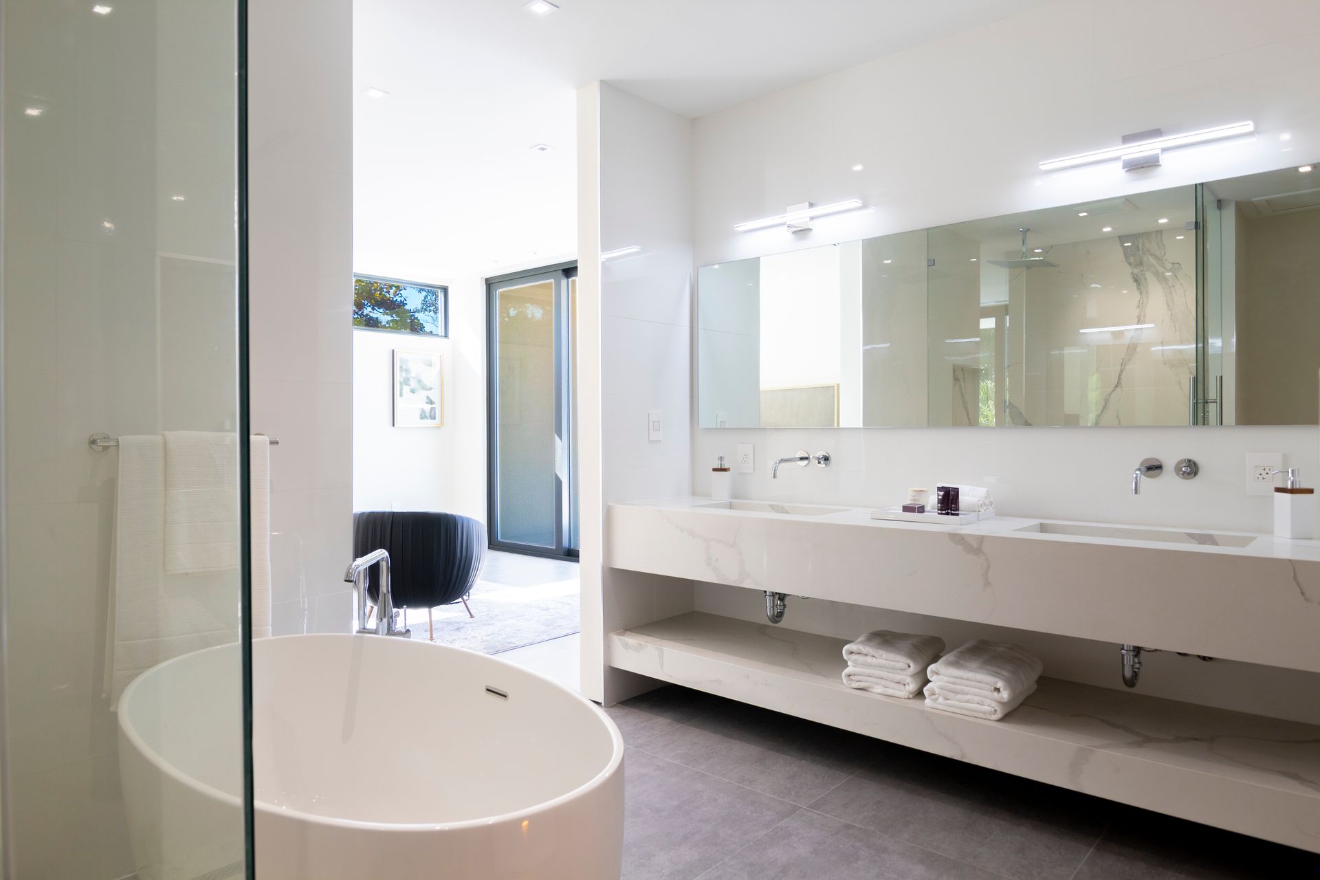 A bathroom with a bathtub , sinks , mirrors and a walk in shower.