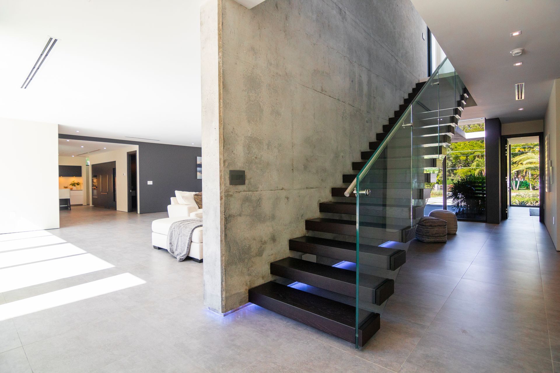 A modern staircase with a glass railing in a house